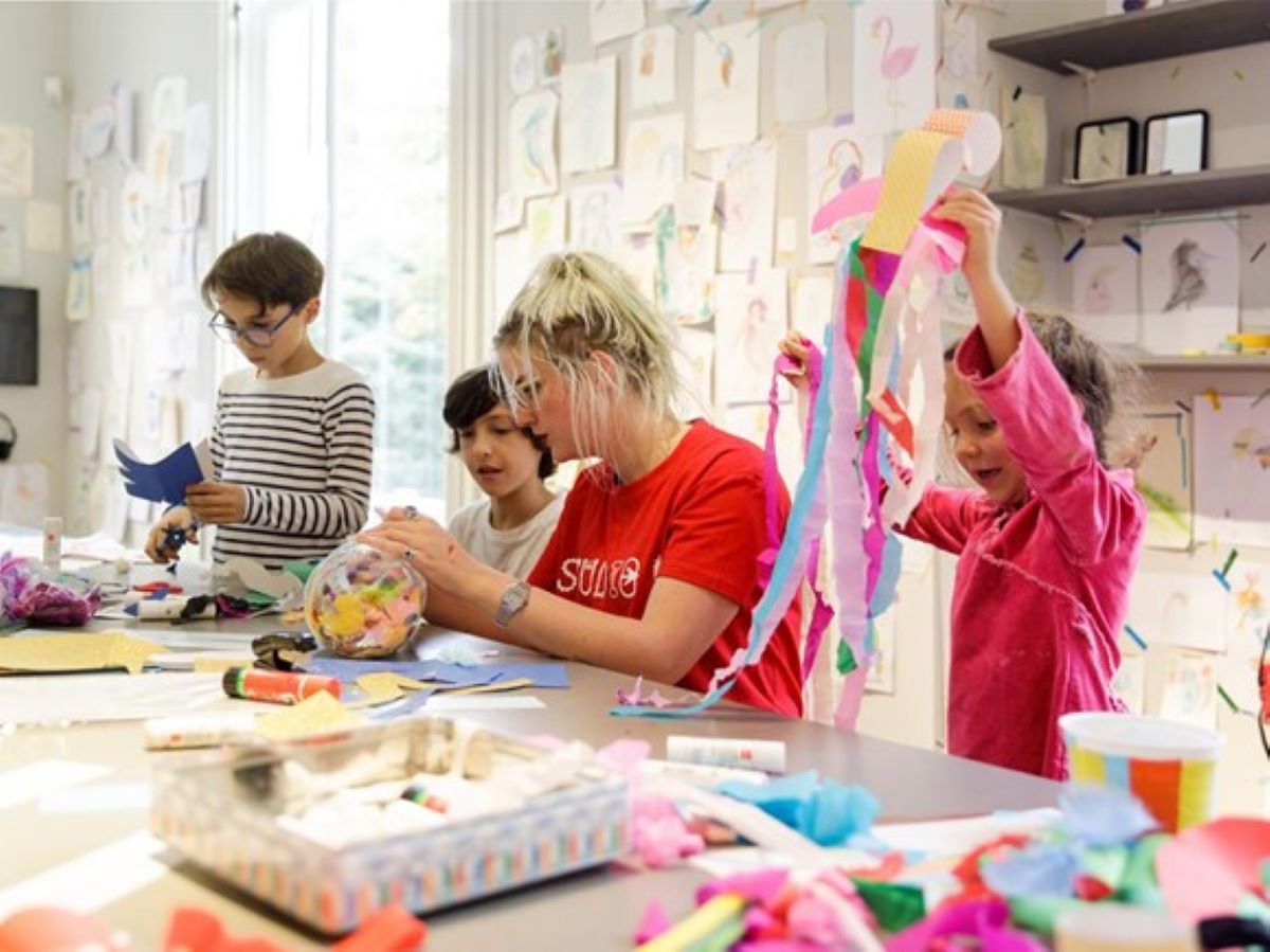 kinderen die met een begeleider aan knutselen zijn